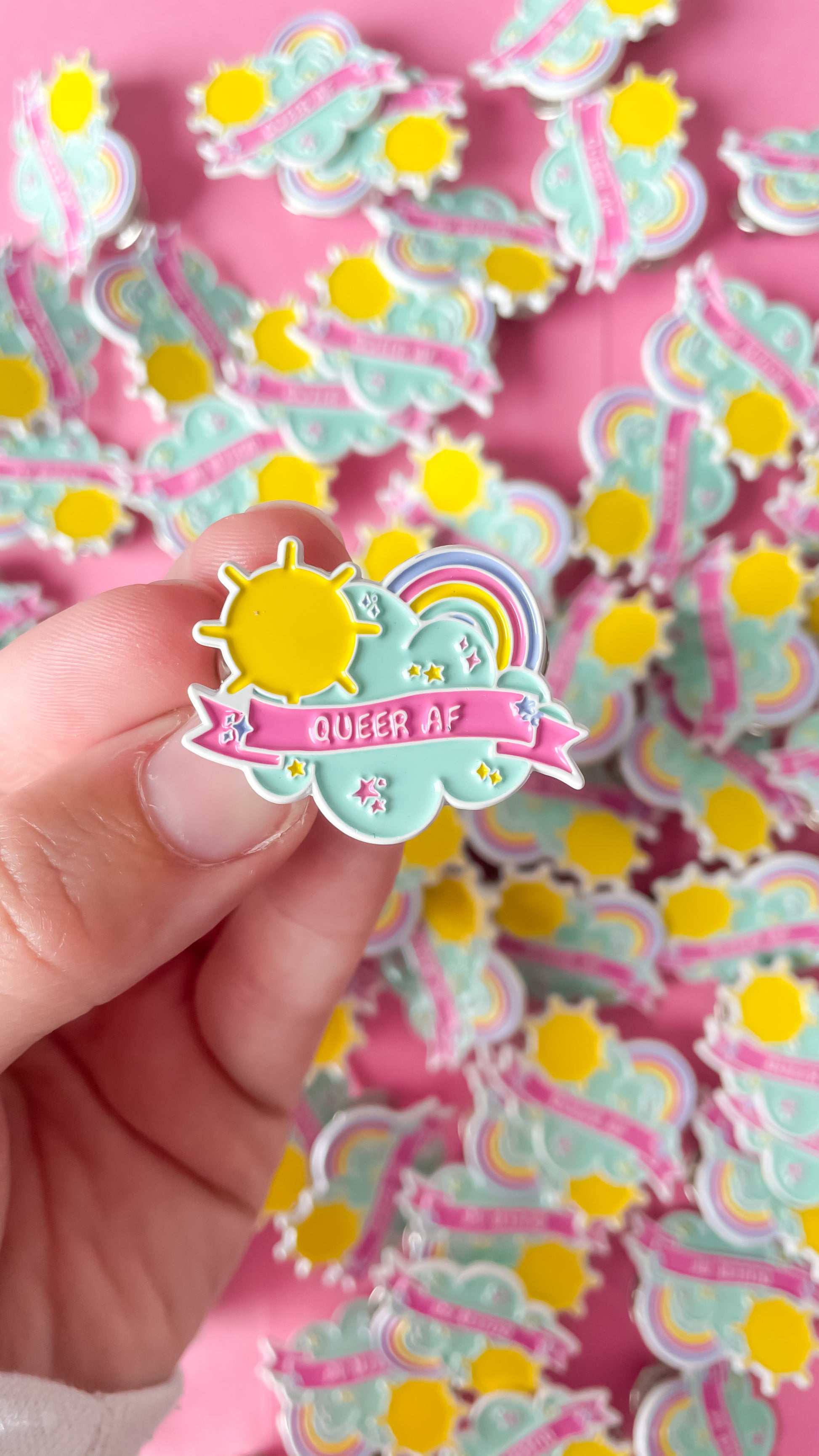 Bright colourful pin that says QUEER AF
